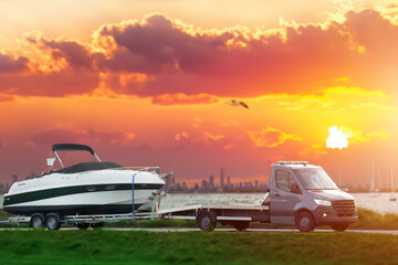 Luxury Boat Journey on the Road at Sunset. Modern motorboat delivery on the driveway. Sunset sky.