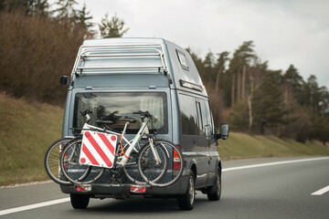 A bike and a camper van on the highway. A family adventure in Europe with a mobile and recreational...