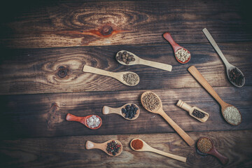 Many different spices in wooden spoons on a wooden background, background with spices, spices in...