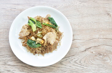 fried rice vermicelli noodles with slice soft marinated pork and Chinese kale in sweet black soybean sauce on plate
