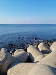 Fototapeta na wymiar Blue Jeju sea with concrete breakwater.