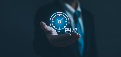 Businessman's hands holding virtual 24-7 with clock on hand For non-stop and full-time contact customer service ,concept oFnon-stop service Digital marketing hotline with wireless technology - obrazy, fototapety, plakaty