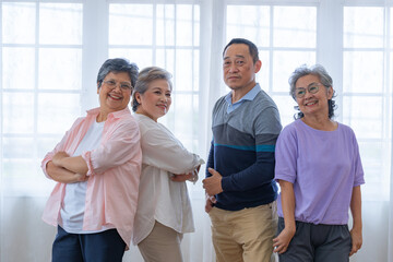 group of asian senior people standing with smart confidence. older people are listening and enjoy meeting focus group at living room. Joyful carefree retired senior friends enjoying relaxation.