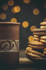 Chocolate and vanilla round cookies on a wooden table with a cup of coffee, round cookies on the...