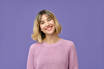Smiling girl with short blond hair, happy confident pretty gen z blonde young woman wearing pink fashion sweater looking at camera standing isolated on purple background. Headshot portrait.