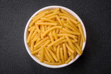 Raw whole grain wheat pasta with salt and spices in a ceramic plate