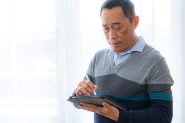 Happiness of male elderly talking with Video Call from smart tablet. Senior people are talking and enjoy together at the living room. Joyful retired friends enjoying relaxation.