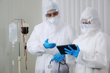 Medical team in Personal Protective Equipment or PPE clothing Researching and Discussing for...