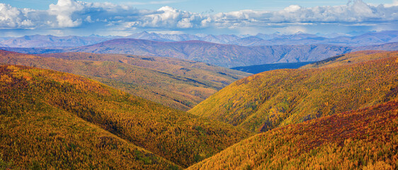 Panorama of a landscape with mountains and rolling hills in autumn colors, Yukon Territory Canada