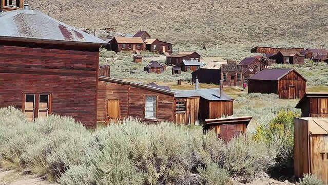 Old city trash can of the 1800s and panorama of the buildings in Bodie state historic park, California Ghost Town. In the United States of America, close to Yosemite national park.