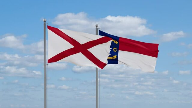 North Carolina and Alabama US state flags waving together on cloudy sky, endless seamless loop