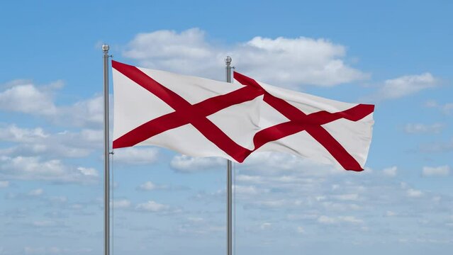 Two Alabama US state flags waving together on cloudy sky, endless seamless loop