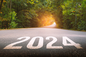 The new year 2024 or straightforward concept. Text 2024 written on the long road in the forest....