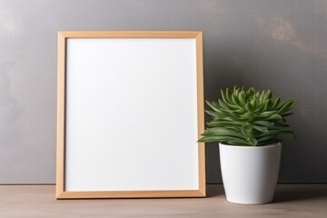 Wooden frame with white blank card mockup and green plant