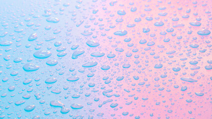 Water drops in neon lighting. Abstract unicorn colored background. Colorful texture backdrop