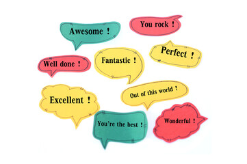 Colorful bubble speech paper cards with compliment words. Awesome. You rock. Well done., Excellent....