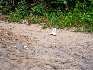 White wedding shoes on the sand in forest