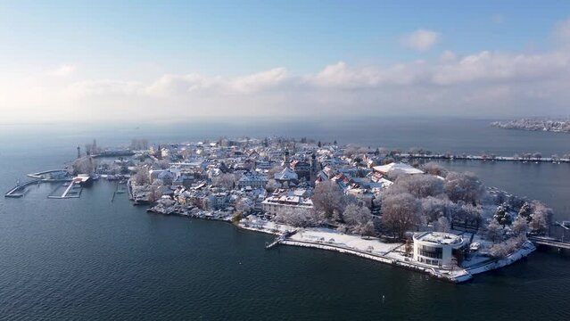 Lindau im Winter, Wintermärchen am Bodensee, die winterliche, mittelalterliche Inselstadt Lindau mit schneebedeckten Häusern und blauem Himmel mit Wolken am Horizont, Spielbank