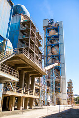 Cement factory. Pipes and compressors, equipment, metalurgy. Modern technologies work at a cement plant. Technological work on the production of cement. Working atmosphere with copy space. - obrazy, fototapety, plakaty