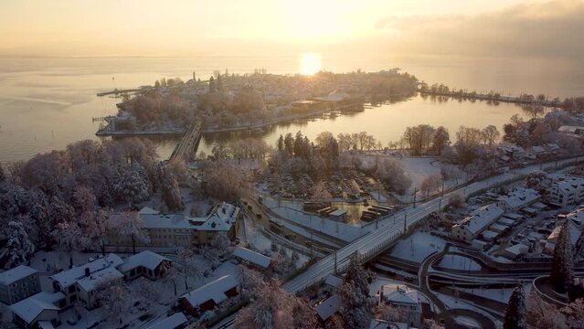 Winterstimmung am Bodensee, Inselstadt Lindau, Blick über die Lindauer Insel bei Sonnenuntergang im Winter, mit schneebedeckten Dächern und Reif an den Bäumen