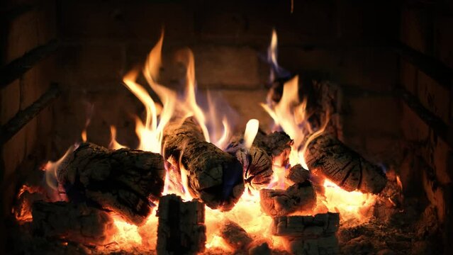 A fireplace with burning logs. Fire in the fireplace. A cozy place to rest. Fire and firewood as background. Burning wood in the furnace. Fire video