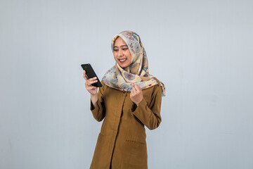 Young Indonesian Woman government employee wearing a brown uniform. Holding and looking to smartphone. On isolated white background