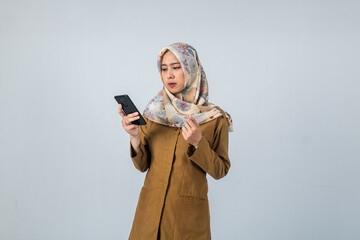 Young Indonesian Woman government employee wearing a brown uniform. Holding and looking to smartphone. On isolated white background