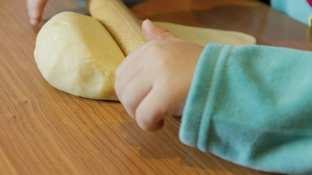 Adorable preschool boy in elf costume using rolling pin to make cookies. Christmas holidays. High quality 4k footage