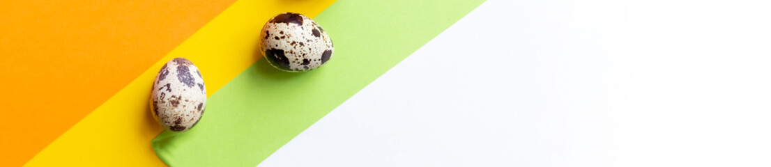 Creative layout with Fresh organic quail egg on bright yellow background. Quail eggs pattern. Happy easter concept. Minimal design. Copy space, flat lay, from above
