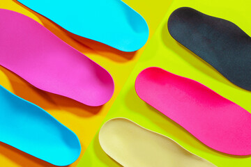 Orthopedic insoles for shoes on a colour background. Foot care