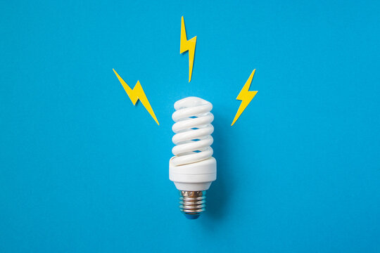 Light bulb with energy lightings on blue background. Idea concept. Energy and electricity. Innovation and thinking out the box symbols. Creativity and inspiration