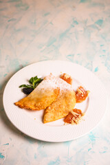 sweet pasties with sugar sprinkles on a white plate