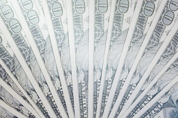 one hundred dollars bills spread out fan shape