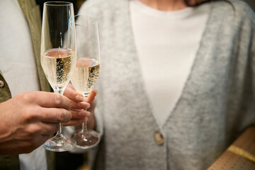Woman and man celebrating New Year holidays toasting with glass of champagne