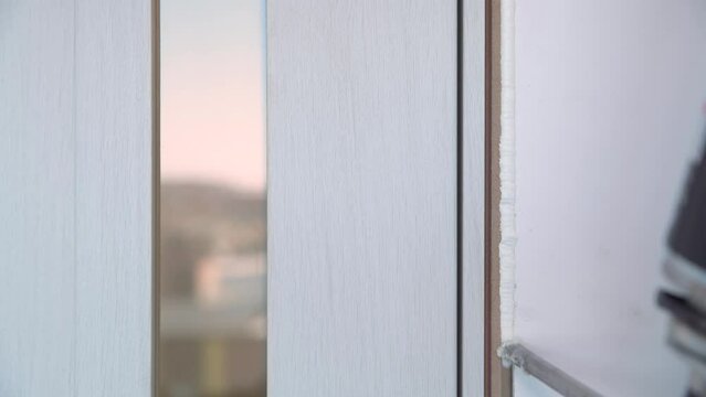 Foaming cracks in the door frame with mounting foam. Construction and repair. Installation and fastening of a wooden frame.