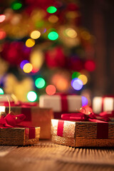 Christmas time. Christmas presents on rustic wooden table. Shallow depth of focus. Colorful bokeh lights.