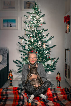 Woman and dog by Christmas tree