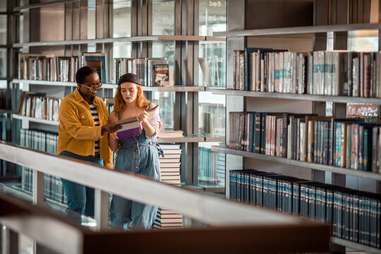 Two young female students studying together in the library