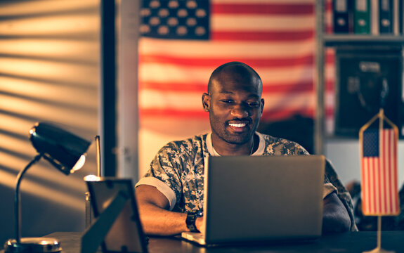 American soldier using a laptop while deployed in an army base