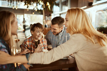 Young family having fun in Christmas decorated cafe