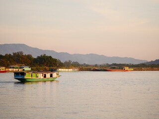 slow boat cruising along the Mekong River, Local boat moving on Mekong river between the border of Thailand and Laos, Boat transport on the river, transport ship