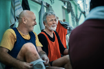 Senior men laughing in locker room before football game
