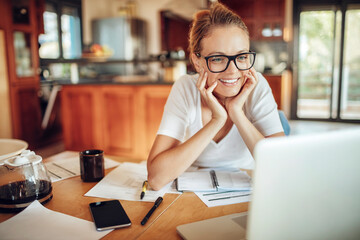 Happy Young Woman Working on Laptop at Home
