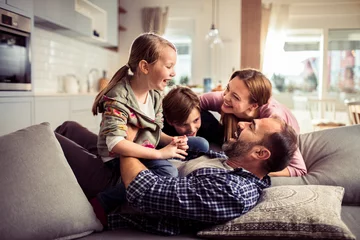 Foto op Canvas Happy family having fun on the couch at home © Geber86