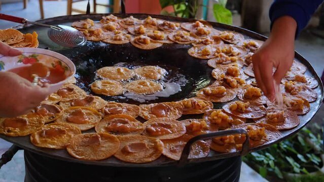 preparation of traditional red enchiladas from Rioverde San Luis Potosi. Fried red tortilla enchilada