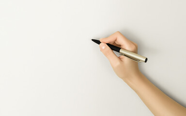 hand writes with a pen on empty gray space