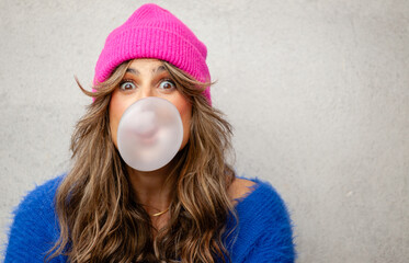 Portrait of beautiful woman smiling with a big bubble gum bubble