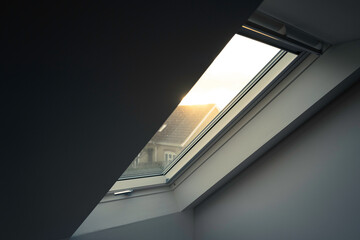 Newly installed, high insulated skylight window seen within the first floor of a house extension. Looking out to a neighbour's house at dusk. - obrazy, fototapety, plakaty