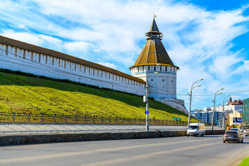 Tower and wall of the Astrakhan Kremlin against the background of moving cars are out of focus.Trip...