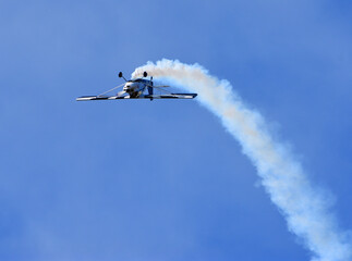 American Champion 8KCAB Decathlon aircraft stunt flying with smoke.